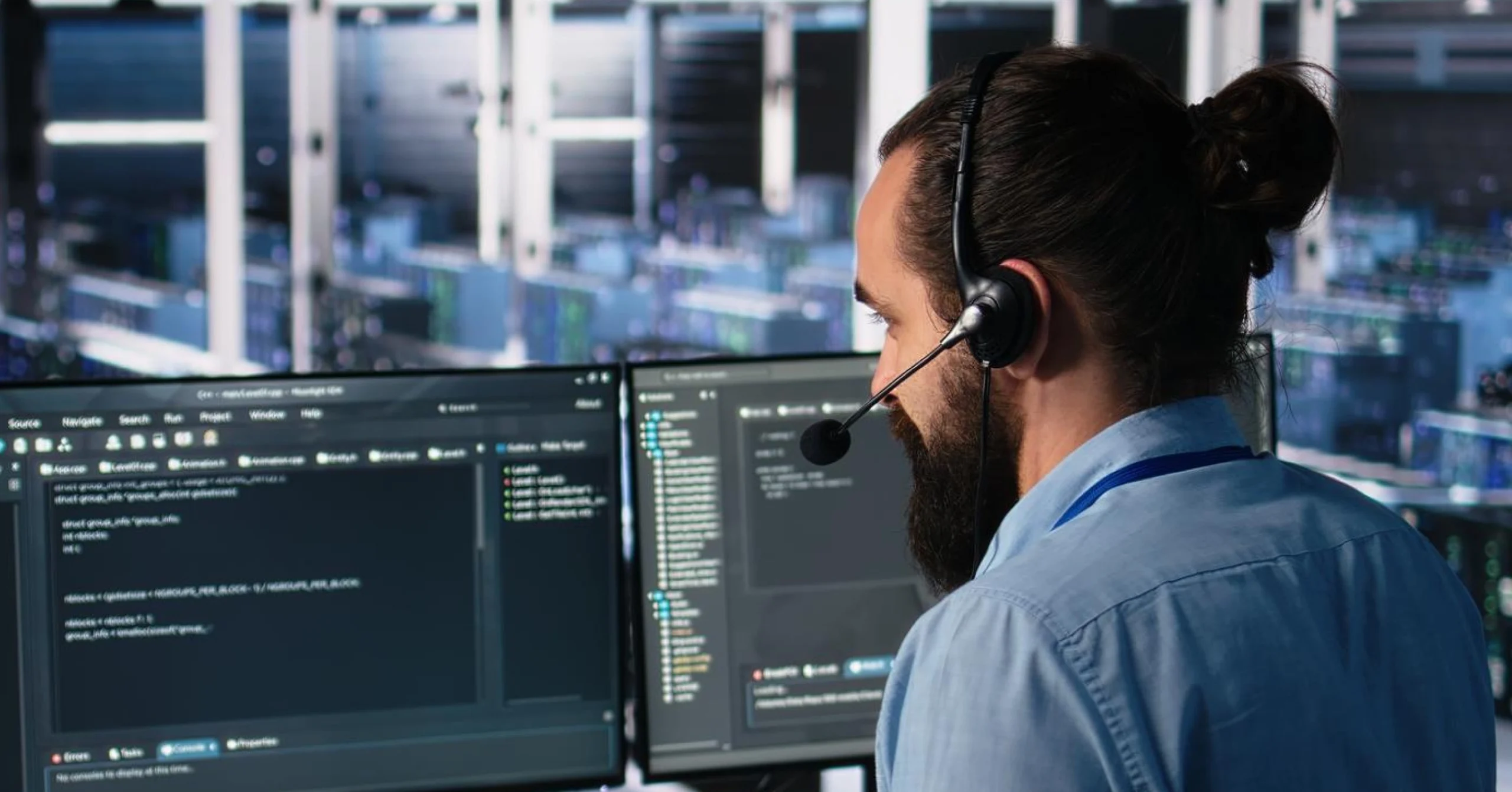 IT support specialist solving computer issues while monitoring multiple screens in a data center environment.